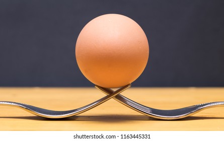 egg balanced on forks