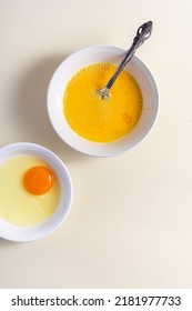 Egg Beat, Egg Shell. Raw Eggs In A Glass And White Bowl On The Table. Flat Lay. Broken White Background. 