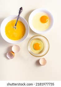 Egg Beat, Egg Shell. Raw Eggs In A Glass And White Bowl On The Table. Flat Lay. Broken White Background. 