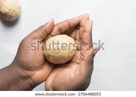 Egg being wrapped in dough to make nigerian egg roll, process of making nigerian egg roll and small chops