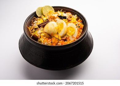 Egg Biryani - Basmati rice cooked with masala roasted eggs and spices and served with yogurt, selective focus