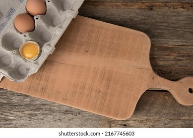 Egg Carton With 2 Whole Brown Eggs And One Cracked Egg With Yellow Yolk. 