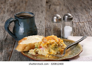 Egg, Cheese, Peppers, Onion And Sausage Breakfast Casserole Served With Coffee On 
A Rustic Table Plate, Fork And Napkin