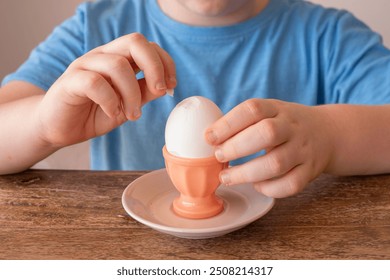 Egg in egg cup for kids breakfast. Egg in the hands of a child. - Powered by Shutterstock