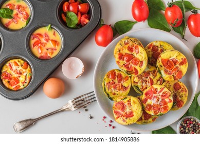 Egg Muffin Cups Or Omelette With Spinach And Tomatoes In A Plate And In Muffin Tin With Fork. Healthy Keto Diet Breakfast. Cooking Concept. Top View