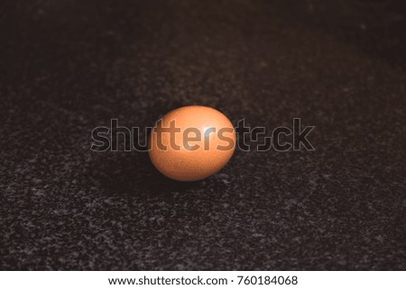 Egg on black marble desk, flare from right upper, food and nutrition for healthy concept.