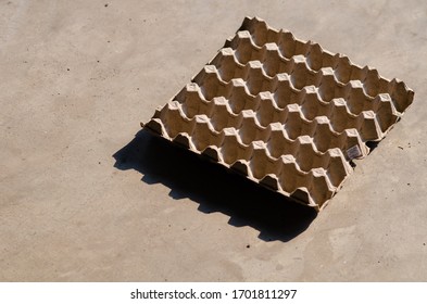 The egg panel is empty on cement floor.