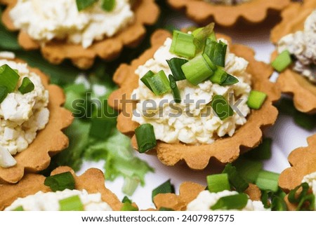 Egg paste cupcake. Egg spread tartlets. Boiles eggs with mayo on baked tarta cake sprinkled with chives onion spring. Salty party snack. Eggs salad on tartlet.