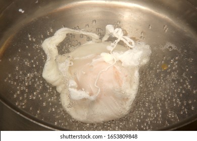 An Egg Poaching In A Pan Of Boiling Water