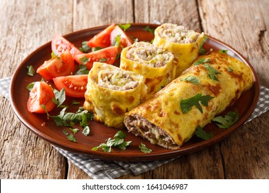 Egg Roll With Meat, Cheese And Pickled Cucumbers Close-up In A Plate Served With Tomatoes On The Table. Horizontal
