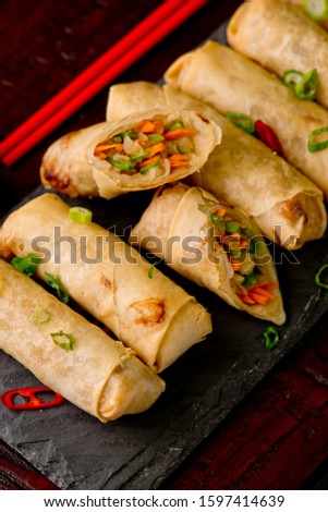 Egg rolls or spring rolls fried.Traditional Chinese Thai restaurant appetizer, spring rolls or egg rolls. Made from wonton wrappers and filled with Chinese veggies and served w/ chili dipping sauce. 