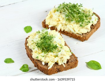 Egg Salad Over Brown Bread With Garden Cress. White Background.  Homemade Spread Made From Eggs, Mayonnaise And Mustard.