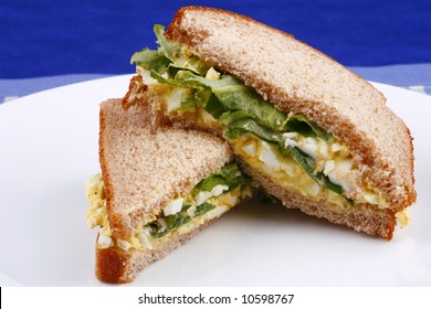 Egg Salad Sandwich On White Plate With Blue Background