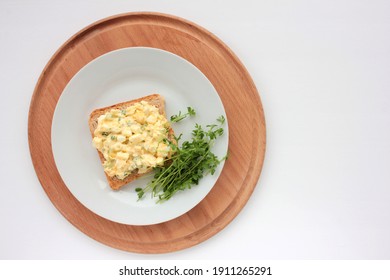 Egg Salad Sandwich With Whole Wheat Toasted Bread And Microgreens On Plate On White Background. Healthy Food Concept. Top View, Selective Focus