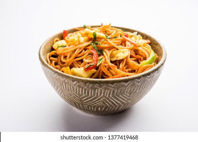 Egg Schezwan/hakka noodles, popular indochinese food served in a bowl with chopsticks. selective focus