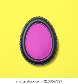 Egg shape made of car tire on a bright yellow background  with a pink fill. Minimal easter concept.  Flat lay.