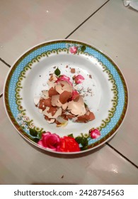 egg shells in a floral patterned plate, in a photo in a bright room. 