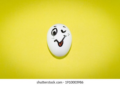 Egg with a smile on a yellow background. - Shutterstock ID 1910003986