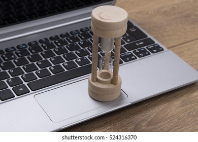 Egg Timer Or Hourglass On An Open Business Laptop With Running Sand Counting Down To A Deadline Conceptual Of Urgency And Stress