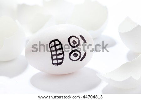 Egg which is afraid lies among a shell on a white background