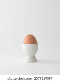 Egg in an white eggcup on a white background.