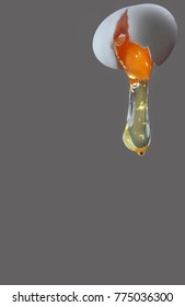 Egg Yolk Dripping, Falling, On Grey Background.