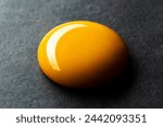 Egg yolk on black background, close up shot