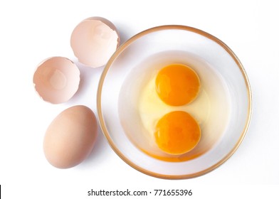 Egg with yolks in a glass bowl and egg shells, over white background - Powered by Shutterstock