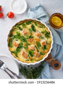 Egg-based Frittata, Omelette With Salmon, Broccoli And Spinach. Italian Dish, Crustless Quiche With Eggs, Fish And Vegetables. Mediterranean Ketogenic Healthy Diet. Top View, Vertical