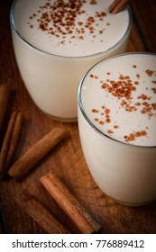 Eggnog houmemade with cinnamon and kakao for Christmas and winter holidays or wooden broun backgrounds
