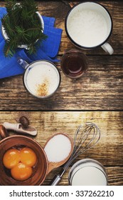 Eggnog  Ingredients On Rustic Wooden Table Viewed From Above.  Egg Milk Punch With Raw Egg Yolks, Milk, Cream, Sugar,  Bourbon, Ground Nutmeg