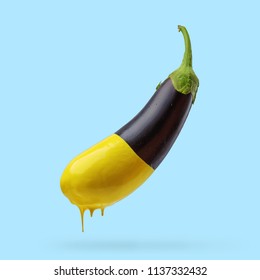 Eggplant With Dripping Yellow Paint On Blue Background. Creative Minimal Food Concept.