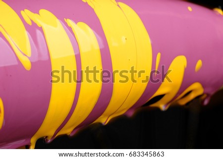 Eggplant with pouring yellow and purple paint background, macro closeup.Texture