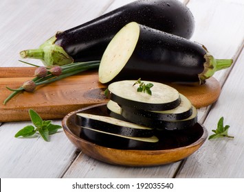 Eggplants  on a wooden table with fresh herbs. Selective focus