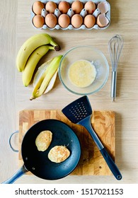 Eggs, Bananas, Banana Pancakes And Equipment For Making Banana Pancakes Laid Out On A Table.