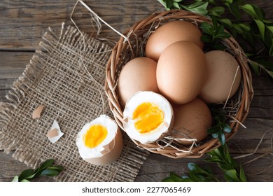 Eggs in basket decorated with boxwood on wooden boards, easter concept  - Powered by Shutterstock