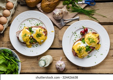 Eggs Benedict with little salad, milk and fresh herbs