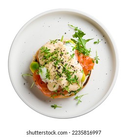 eggs Benedict with salmon and avocado on white plate top view isolated on white background