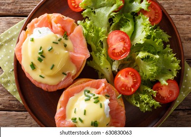 Eggs Benedict With Salmon And Hollandaise Sauce On A Plate Close-up. Horizontal View From Above
