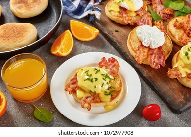 Eggs Benedict - Toasted English Muffins, Fried Crispy Bacon, Poached Eggs And Classic Buttery Hollandaise Sauce Served With Orange Juice For Breakfast, View From Above, Close-up