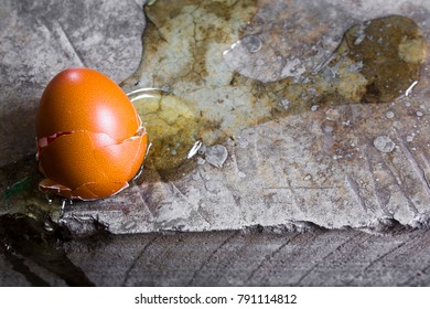 Eggs are broken on cement floor with copy space.