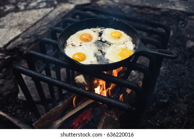 Eggs Cooking In A Cast Iron Fry Pan Over A Fire On A Cool Morning.