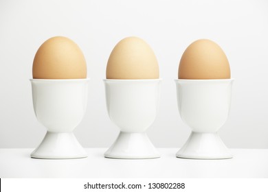 Eggs In Egg Cups On White Table