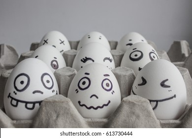 Eggs with faces photo for your design. in the box. Funny and cute. Nine in the foreground smiles