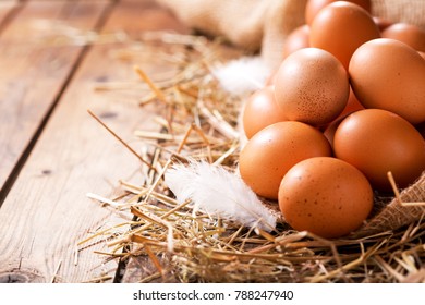 Eggs in a heap of Hay on wooden table - Shutterstock ID 788247940