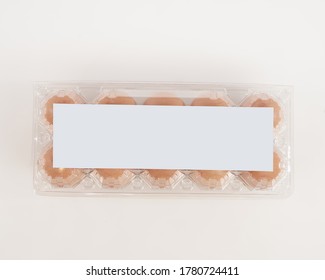 Eggs in plastic packaging with an isolated white background. Mock up the white sticker above for the logo space. These health premium eggs are commonly used for advertising or promo materials.