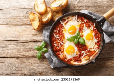 Eggs in Purgatory is a delicious Southern Italian dish consisting of fried eggs in a spicy tomato sauce with onions and garlic closeup on the skillet on the table. Horizontal top view from above
 - Powered by Shutterstock