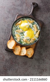 Eggs Sardou Is A Louisiana Creole Cuisine Dish Made With Poached Eggs, Artichoke Bottoms, Creamed Spinach And Hollandaise Sauce Close Up In The Plate On The Table. Vertical Top View From Above
