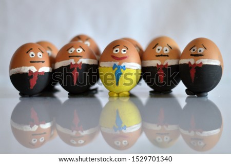 Eggs symbolize that how a person stands out from the crowd. The colorful egg shows itself and the other eggs are the mass, who haven't got their own personality, they want to be accepted by others. 