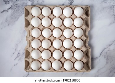 Eggs top view. Packing of fresh chicken eggs on marble background. 30 pieces.